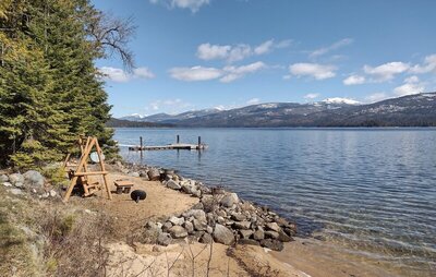 Dock and bench swing of one of the many rustic cottages along the west shore of Priest Lake. Across the lake (right to left/near to far) are Cameis Prairie, Mt. Roothaan, Horton Ridge, Goblin Knob, and Lookout Mountain.