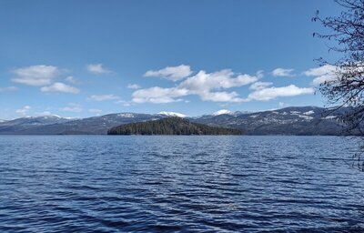 Priest Lake, Bartoo Island, and the east side of Priest Lake. Rising up on the far side of the lake (left to right), are Goblin Knob, Horton Ridge, Mt. Roothaan, Gunsight Peak, Hunt Peak (mostly hidden), and Cameis Prairie.