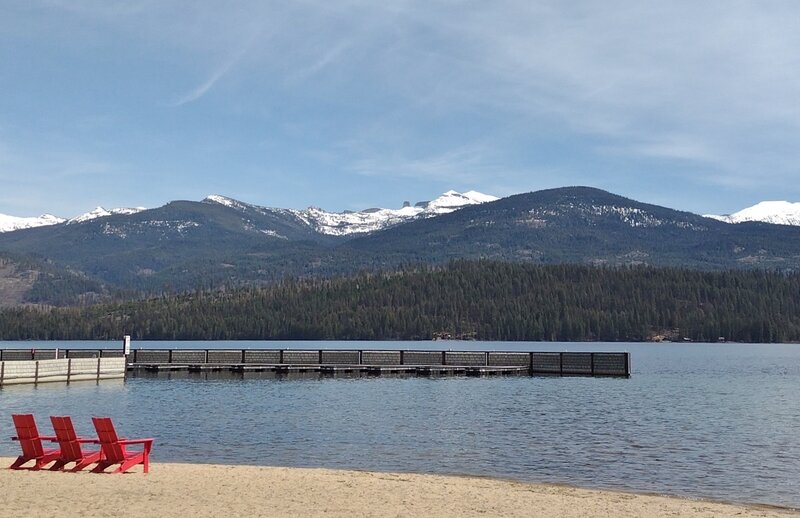 Mt. Roothaan is the snowy peak just right of center. In the center, next to Mt. Roothaan, the knobby "rock" that sticks up is Chimney Rock.  Seen when zooming in, across Priest Lake from the Elkins Resort at the north end of Kalispell - Reeder Bay Trail.