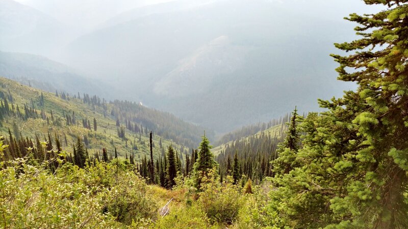 The Upper Priest River valley, on a hazy July morning. The small white spot just left of center, is the Upper Priest River shining in the morning sun.