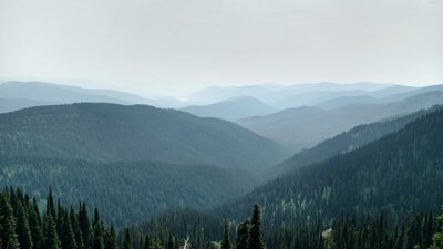 The ridges of Selkirk Mountains, with Upper Priest Lake, the flat white spot among the far ridges, just left of center. Upper Priest Lake is 12 miles away, to the southeast.