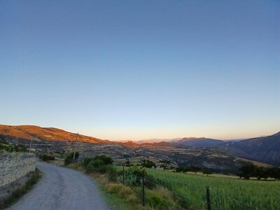 View of the trail and surrounding farmlands during sunset.