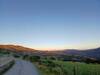 View of the trail and surrounding farmlands during sunset.