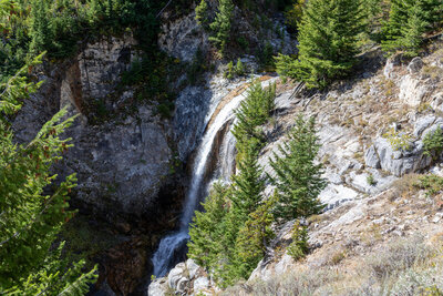 Along the upper reaches of the Ice Lake Trail at 6,796 ft, Adam Creek plunges over a dramatic 50 ft bedrock cliff, cascading through a rugged amphitheater carved into the glaciated hanging valley.
