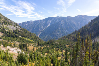 Looking east from an upper switchback of the Ice Lake Trail at 7,224 ft, an expansive vista unfolds down the glaciated hanging valley of Adam Creek toward the deep canyon of the West Fork Wallowa River.